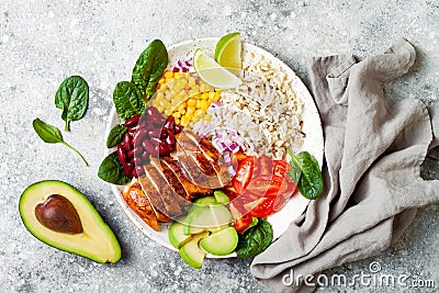 Homemade Mexican chicken burrito bowl with rice, beans, corn, tomato, avocado, spinach. Taco salad lunch bowl. Stock Photo