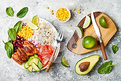 Homemade Mexican chicken burrito bowl with rice, beans, corn, tomato, avocado, spinach. Taco salad lunch bowl. Stock Photo