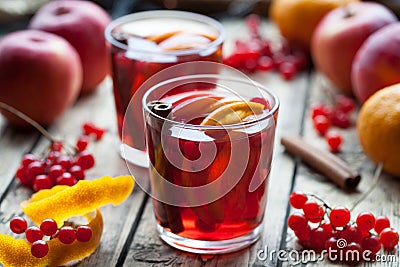 Homemade mulled wine or sangria with orange and apple slices, cranberries, cinnamon, anise on wooden table. Stock Photo