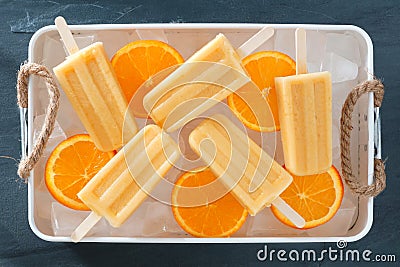 Homemade orange popsicles in a rustic ice tray Stock Photo
