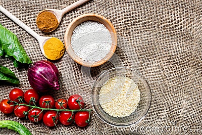 Homemade paella ingredients composition with rice, tomato, onion on fabric background top view mock-up Stock Photo