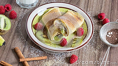 Homemade pancake with vanilla curd, raspberries, kiwi and banana pieces sprinkled with cocoa Stock Photo