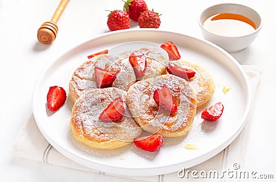 Homemade pancakes with cottage cheese and strawberry slices, syrniki Stock Photo