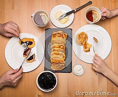 Homemade pancakes. Father and Son Eating at Breakfast Table. Tea Stock Photo