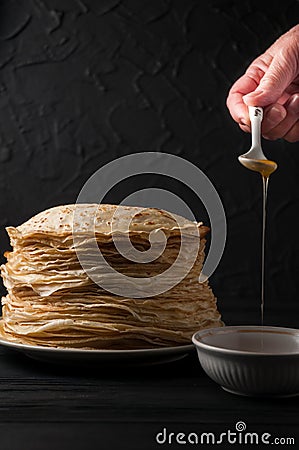Homemade pancakes with honey and walnuts, vintage white plate, dipper, dark wooden table. Stock Photo