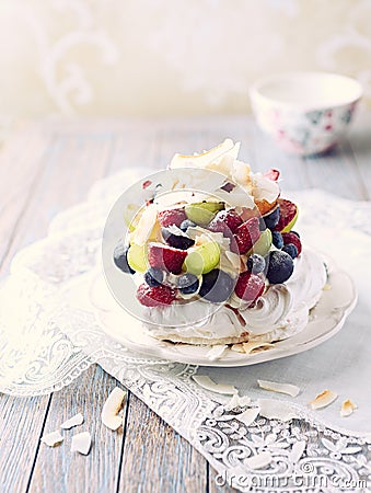 Homemade Pavlova with Fresh Fruits and Coconut; Cake with blueberries, strawberries, grapes, raspberries and coconut Stock Photo