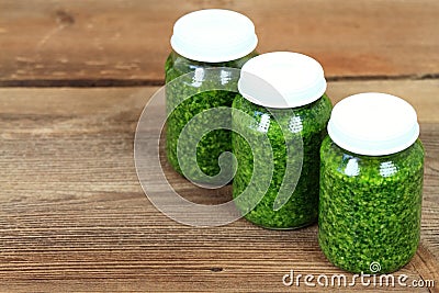 Homemade pesto in jars on rustic wooden table Stock Photo