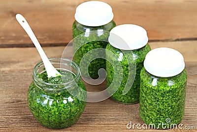 Homemade pesto in jars on rustic wooden table Stock Photo