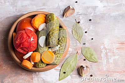 Homemade pickled tomatoes and cucumbers with carrots, garlic and Bay leaf, on a blurred light background. Flat lay. Stock Photo