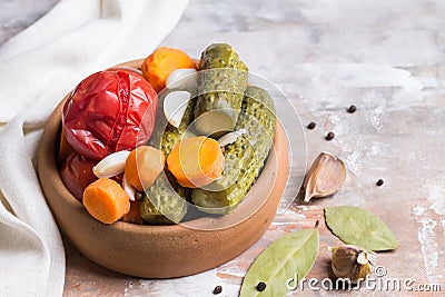 Homemade pickled tomatoes and cucumbers with carrots, garlic and Bay leaf. Blurred light background. Stock Photo