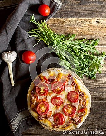 Homemade pizza with ham , tomato and arugula Stock Photo