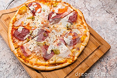 Homemade pizza on a wooden cutting Board on the table closeup Stock Photo