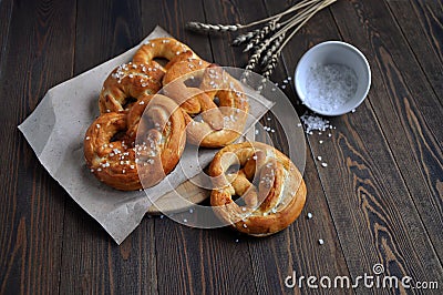 Homemade pretzels, salt and ears of wheat on a dark wooden table Stock Photo