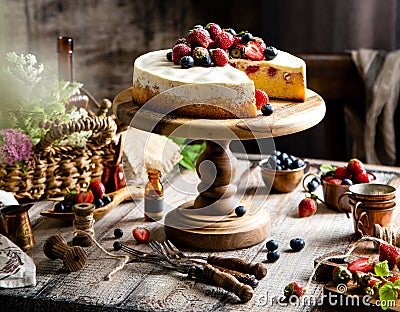 Homemade raspberry sliced biscuit cake with white cream and berries on top on wooden cake stand Stock Photo