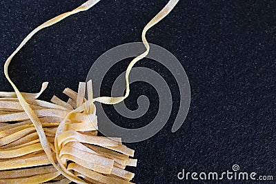 homemade raw uncooked pasta fettuccine, tagliatelle, spaghetti on working table. Raw fresh handmade pasta, italian food at home Stock Photo