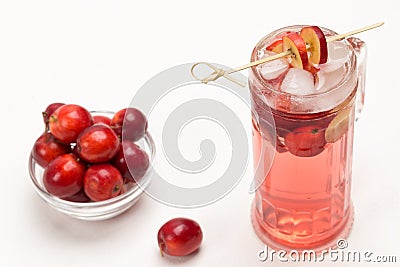 Homemade refreshing summer apple drink with ice in glass. Sliced apples on stick. Small red apples in glass cup Stock Photo