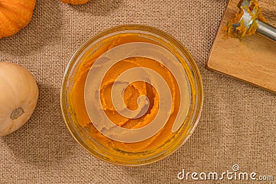 Homemade roasted pumpkin puree from scratch. Fresh puree in a glass bowl close up on kitchen table Stock Photo