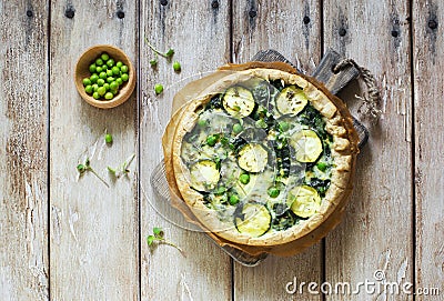 Homemade rustic vegetable pie quiche with spinach, zucchini and green peas Stock Photo