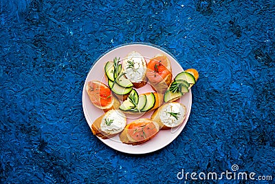 Homemade sandwiches with french baguette, salmon, cheese and vegetable on blue background top view mock-up Stock Photo