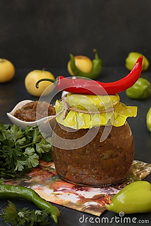 Homemade sauce adjika with hot pepper, garlic, apples, parsley and dill in a jar Stock Photo