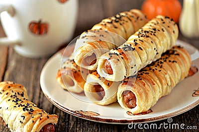 Homemade sausages in puff pastry on wooden background. Stock Photo