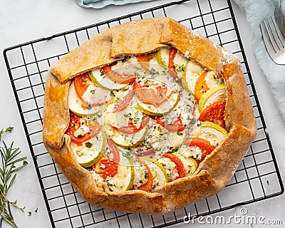 Homemade savory galette with vegetables, wholegrain pie with tomatoes, zucchini, blue cheese Stock Photo