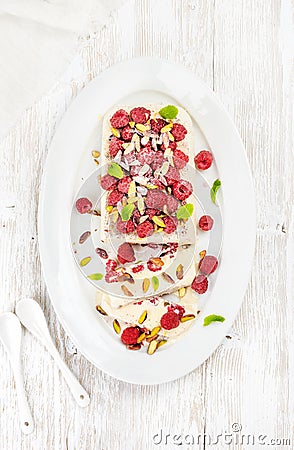 Homemade semifreddo with pistachio and raspberry in white oval dish Stock Photo