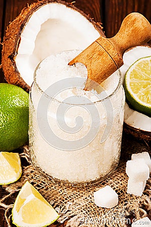 Homemade sugar scrub with lime and coconut on wooden background Stock Photo
