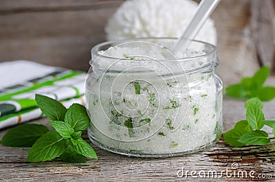 Homemade sugar scrub with vegetable oil, chopped mint leaves and essential mint oil Stock Photo