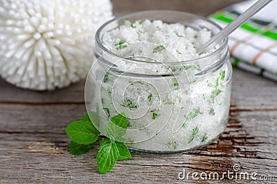 Homemade sugar scrub with vegetable oil, chopped mint leaves and essential mint oil Stock Photo