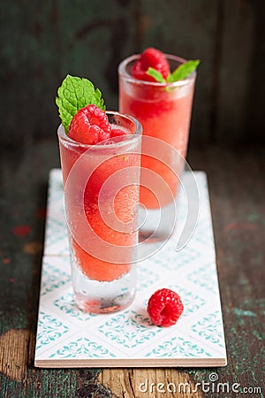 Homemade summer cold raspberry cocktail with crushed iced and alcohol in glasses on a vintage background Stock Photo