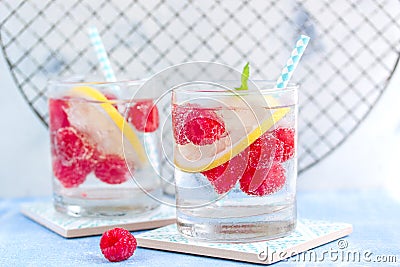 Homemade summer cold raspberry lemon cocktail with sparkling water and crushed iced in glasses Stock Photo