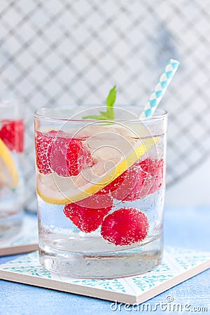 Homemade summer cold raspberry lemon cocktail with sparkling water and crushed iced in glasses Stock Photo