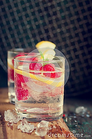 Homemade summer cold raspberry lemon cocktail with sparkling water and crushed iced in glasses Stock Photo