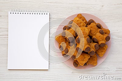 Homemade Sweet Bear Cookies on a pink plate, blank notepad on a white wooden background, top view. From above, flat lay, overhead Stock Photo
