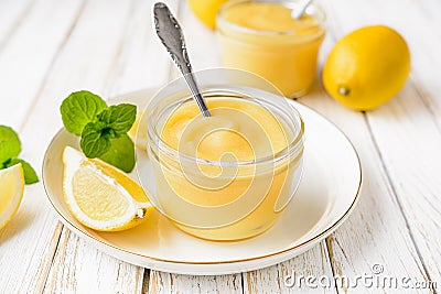 Homemade tangy lemon curd decorated with fresh fruit in a glass jars on rustic wooden background Stock Photo