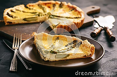 Homemade tart with asparagus and cheese on black background. Stock Photo