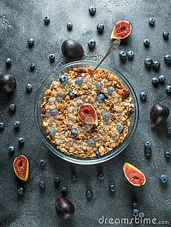 Homemade tasty muesli with nuts in glass bowl, berries and figs fruits. Healthy vegetarian breakfast. Stock Photo