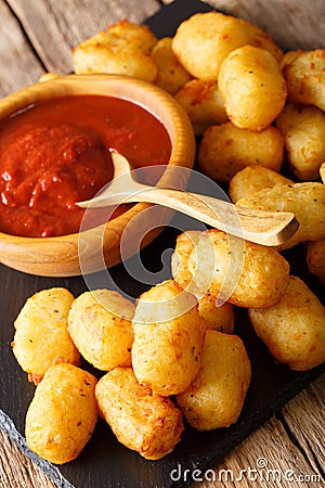 Homemade tater tots with tomato sauce close up. Vertical Stock Photo