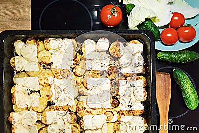 Homemade traditional casserole of potatoes,cut into plastics,baked with cheese in the oven until golden brown,surrounded by Stock Photo