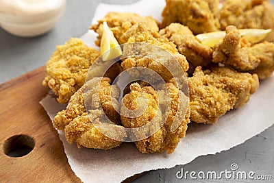 Homemade traditional japanese fried chicken Karaage on a rustic wooden board over gray background, low angle view. Closeup Stock Photo