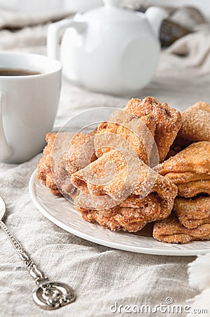 Homemade triangle cookies with curd filling sprinkled with sugar. On a white plate. Background gray linen. In the background is a Stock Photo