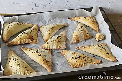 Homemade triangle pies on oven-tray Stock Photo