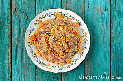 Homemade vegan pumpkin pilaf in colorful plate on turquoise tabl Stock Photo