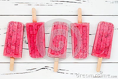 Homemade vegan raspberry coconut milk popsicles - ice pops - paletas with chia seeds on rustic white wooden background. Stock Photo