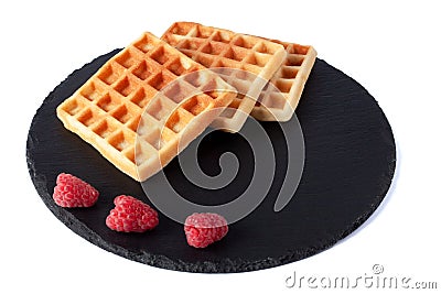 Homemade waffles with berries on black stone plate isolated. Belgian waffle with fruit raspberry on white background. Stock Photo