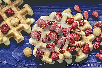 Homemade waffles with berries oo blue, purple wooden background. Delicious, nutritious, fantastic breakfast or dessert Stock Photo