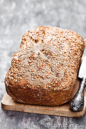 Homemade wholemeal rye bread with flax seeds on wooden table Stock Photo