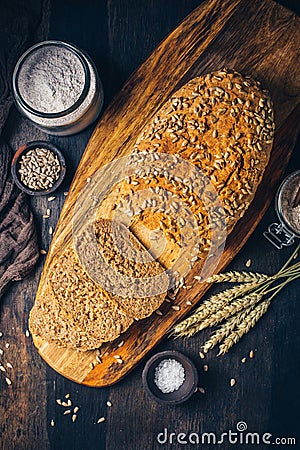 Homemade wholemeal spelt bread with sunflower seeds and baking ingredients Stock Photo