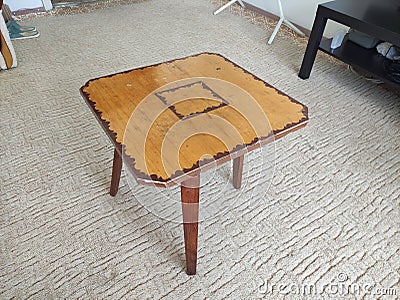 Homemade wooden three-legged magazine table Stock Photo